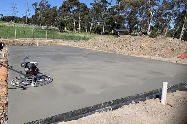 Freshly poured concrete slab being cured with proper moisture retention methods