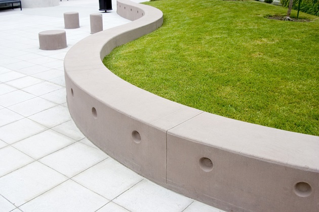 Sleek concrete retaining wall supporting a sloped driveway, enhancing property access