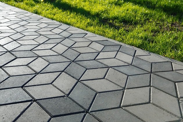 Modern residential driveway with plain concrete centre and decorative stamped concrete borders